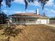 Charming single-story home with a covered front porch, manicured lawn, and mature trees creating a welcoming curb appeal at 4000 Barbary Ln, North Port, FL 34287