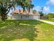 Charming single-story home featuring a sprawling green lawn, mature tree, and a welcoming front porch at 4000 Barbary Ln, North Port, FL 34287