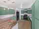 Updated kitchen featuring jade green cabinets, granite countertops, stainless steel appliances, and wood-look flooring at 4000 Barbary Ln, North Port, FL 34287