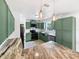 Stylish kitchen featuring modern appliances, granite countertops, and custom green cabinetry at 4000 Barbary Ln, North Port, FL 34287
