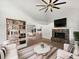 Bright living room features a stone fireplace, hardwood floors, built-in shelves, and an open-concept dining area at 4000 Barbary Ln, North Port, FL 34287