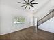 Bright living room with wood floors, staircase, and vaulted ceilings at 4000 Barbary Ln, North Port, FL 34287