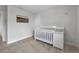 Minimalist Bedroom with neutral carpet and soft grey walls features a crib with a changing table at 13015 Homestead Ln, Parrish, FL 34219