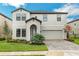 Charming two-story home boasts manicured lawn, brick driveway, and attached two car garage at 13015 Homestead Ln, Parrish, FL 34219