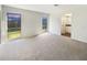 Spacious carpeted living room with bright windows, white walls, and an open entryway at 14315 Knoll Ridge Dr, Tampa, FL 33625