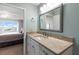 Well-lit bathroom featuring a vanity with stone countertop and a view to the main bedroom with ocean view at 500 The Esplanade N # 405, Venice, FL 34285