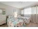 Cozy bedroom with two twin beds, bright patterned bedding, and natural light from a window at 500 The Esplanade N # 405, Venice, FL 34285