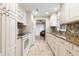 Galley kitchen with granite countertops, white cabinets, and stainless steel appliances at 500 The Esplanade N # 405, Venice, FL 34285