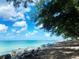 Beautiful ocean view with clear turquoise water and rocky shoreline under a bright blue sky at 500 The Esplanade N # 405, Venice, FL 34285