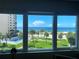 Breathtaking ocean view from a large window, showcasing a pool, beach, and palm trees on a sunny day at 500 The Esplanade N # 405, Venice, FL 34285