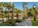 Lovely street view featuring lush landscaping, flowers, and a vintage-style clock at 500 The Esplanade N # 405, Venice, FL 34285