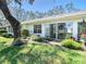 Backyard view showcasing mature trees, landscaping, and sliding glass doors to the patio at 4215 Edgewood Dr, Holiday, FL 34691