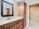 Bathroom featuring a dark framed mirror, wood cabinets, and a step-in shower at 4215 Edgewood Dr, Holiday, FL 34691