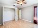 Bedroom with wood floors, ceiling fan, and closet with folding doors at 4215 Edgewood Dr, Holiday, FL 34691