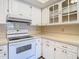 Bright kitchen offers white cabinetry, a range, and light countertops at 4215 Edgewood Dr, Holiday, FL 34691