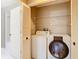 A well-equipped laundry area with washer, dryer, shelving, and access to an adjacent bathroom at 4215 Edgewood Dr, Holiday, FL 34691