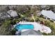 Aerial view of the community pool with lounge seating and mature trees surrounding the area at 4215 Edgewood Dr, Holiday, FL 34691