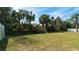 Over-sized backyard featuring a verdant lawn, mature trees, and a sturdy white fence, creating privacy at 5320 Aqua Breeze Dr, Bradenton, FL 34208