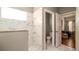 Modern bathroom with a granite countertop, and a large mirror with a window next to the toilet at 5320 Aqua Breeze Dr, Bradenton, FL 34208