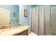 Bright bathroom with blue walls, marble countertop sink, and a patterned shower curtain adding character to the space at 5320 Aqua Breeze Dr, Bradenton, FL 34208