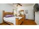 Bright bedroom featuring hardwood floors, ceiling fan, and a classic wooden bed frame and matching dresser at 5320 Aqua Breeze Dr, Bradenton, FL 34208