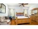Bright bedroom featuring hardwood floors, ceiling fan, and a classic wooden bed frame and matching dresser at 5320 Aqua Breeze Dr, Bradenton, FL 34208