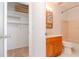 Hallway view of bathroom with wooden vanity and walk-in closet with adjustable metal shelving at 7710 Danube Dr # A, Hudson, FL 34667