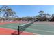 Well-maintained tennis court with vibrant green and red surfaces, perfect for recreational play at 7710 Danube Dr # A, Hudson, FL 34667
