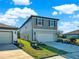 Charming two-story home features a two-car garage, green landscaping, and light-blue painted facade at 9189 Royal River Cir, Parrish, FL 34219
