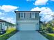 Charming two-story home features a two-car garage, green landscaping, and light-blue painted facade at 9189 Royal River Cir, Parrish, FL 34219