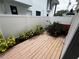 Cozy patio featuring light wood decking, green plants, red flowers, and a white privacy fence at 2607 W Cleveland St # B, Tampa, FL 33609