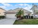Charming single-story home with well-manicured lawn and a two-car garage, nestled under a sunny sky at 30350 Grymes Dr, Wesley Chapel, FL 33545
