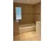 Relaxing bathroom with a shower over the bath and neutral tile at 3818 Moog Rd, Holiday, FL 34691