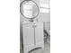 Bright bathroom featuring a round mirror and a white vanity at 3818 Moog Rd, Holiday, FL 34691