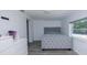 Neat bedroom featuring grey hardwood floors, a comfortable bed, and a bright window at 3818 Moog Rd, Holiday, FL 34691