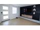 Modern living room with a large mounted television and floating shelving at 3818 Moog Rd, Holiday, FL 34691
