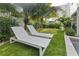 Manicured backyard with putting green, mature tropical landscaping, and lounge chairs at 415 N Bay Blvd, Anna Maria, FL 34216