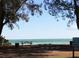 Picturesque beach park with picnic tables and a view of the water and bridge in the distance at 415 N Bay Blvd, Anna Maria, FL 34216