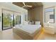 Bright bedroom with a platform bed, a wood accent wall, and balcony access with scenic water views at 415 N Bay Blvd, Anna Maria, FL 34216