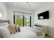 A sunlit bedroom features a ceiling fan, a large window, and stylish decor elements at 415 N Bay Blvd, Anna Maria, FL 34216