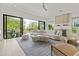 Open-concept living room with hardwood floors, modern furniture, wet bar, and a balcony at 415 N Bay Blvd, Anna Maria, FL 34216