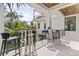 Outdoor deck featuring tall tables with bar stools and scenic views of lush greenery, perfect for entertaining at 415 N Bay Blvd, Anna Maria, FL 34216