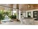 Covered outdoor entertainment area with table tennis and view of the pool at 415 N Bay Blvd, Anna Maria, FL 34216