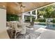 Inviting covered patio with dining area, kitchen, pool, and vertical garden at 415 N Bay Blvd, Anna Maria, FL 34216