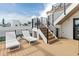 Multi-level rooftop deck with wood flooring, modern railing, and convenient staircase access at 415 N Bay Blvd, Anna Maria, FL 34216