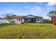Spacious, grassy backyard showcases a screened-in patio, a white fence, and mature trees at 4107 Mulgrave Ave, North Port, FL 34287