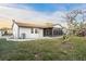 View of the house showing the screened-in patio, backyard, and a large grassy lawn at 4107 Mulgrave Ave, North Port, FL 34287