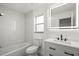 Bright bathroom with LED mirror, white vanity, tiled walls, and a shower-tub combination at 4107 Mulgrave Ave, North Port, FL 34287