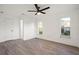 Bright bedroom featuring modern ceiling fan, light gray wood floors, and bright, window-lit walls at 4107 Mulgrave Ave, North Port, FL 34287