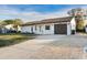 A single story home with an extra long driveway made of light brown pavers in a well manicured lawn at 4107 Mulgrave Ave, North Port, FL 34287